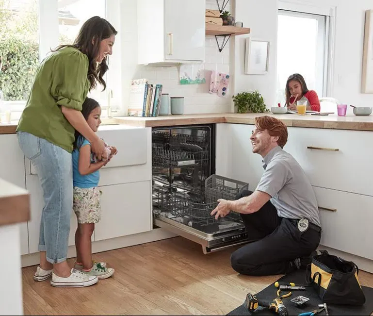 Appliance King technician servicing a dishwasher in a modern kitchen